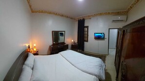 A hotel room with a bed, bedside tables, a mirror, a TV, and a wardrobe. - Sphinx Safari (Giza)