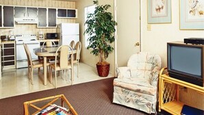 A compact living space with a kitchen, dining area, and a seating area with a television.