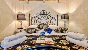 Une chambre à coucher avec un lit, deux lampes de chevet, une tête de lit décorative et un arrangement floral.