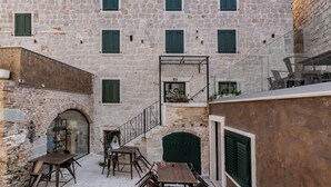 Un bâtiment en pierre doté de nombreuses fenêtres et d’un escalier menant à un étage supérieur.