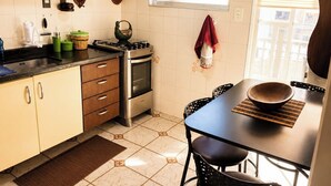 Une cuisine équipée d’une cuisinière, d’un four et d’une table à manger avec des chaises.