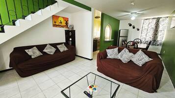 Relax in this stylish living room with a sofa, coffee table, and staircase leading to an upper level.