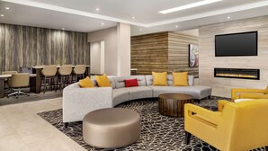 Uma sala de estar moderna com um sofá em formato de L, uma mesa de centro e poltronas amarelas. Há uma área de jantar com mesa e cadeiras ao fundo.