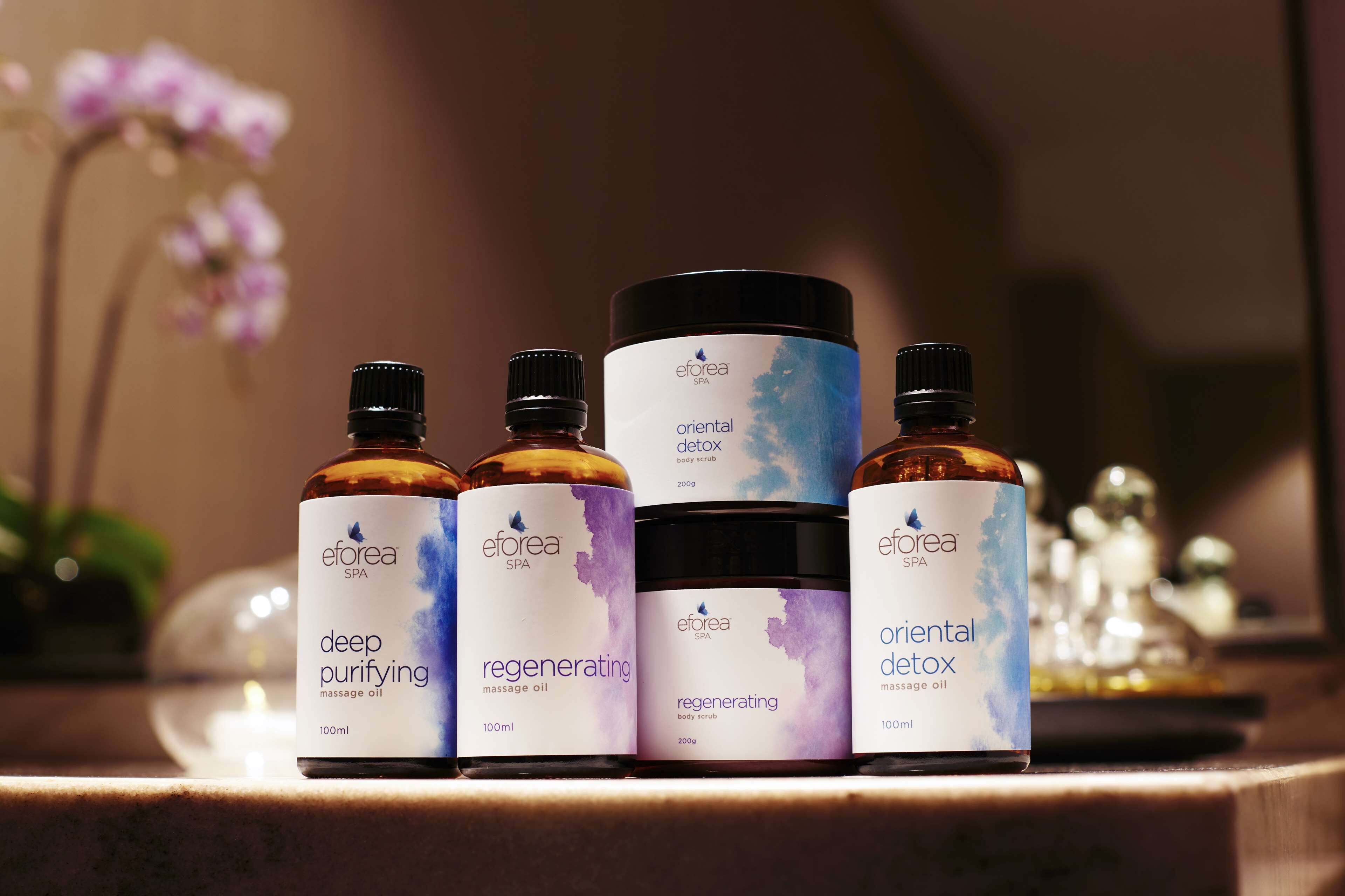 Un conjunto de productos de spa Efora, incluyendo aceite de masaje y exfoliante corporal.