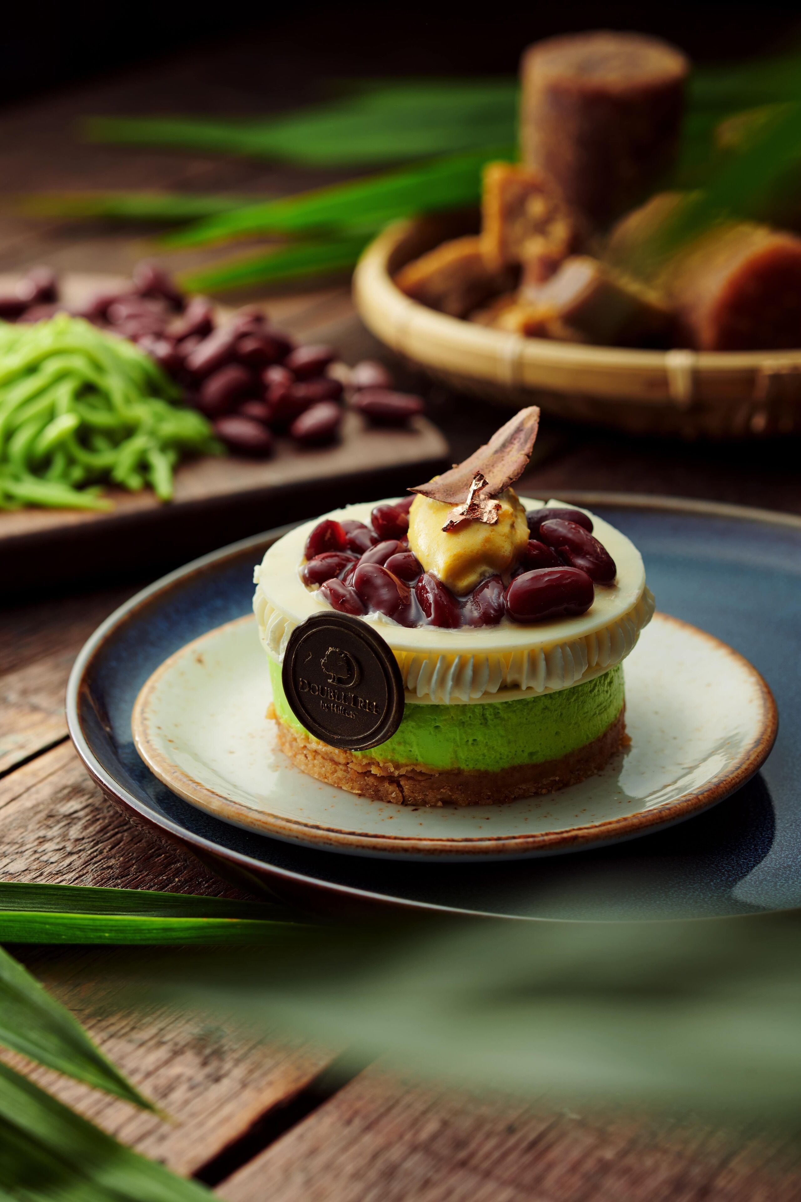 A dessert on a plate with a label, surrounded by green leaves and a wooden table.