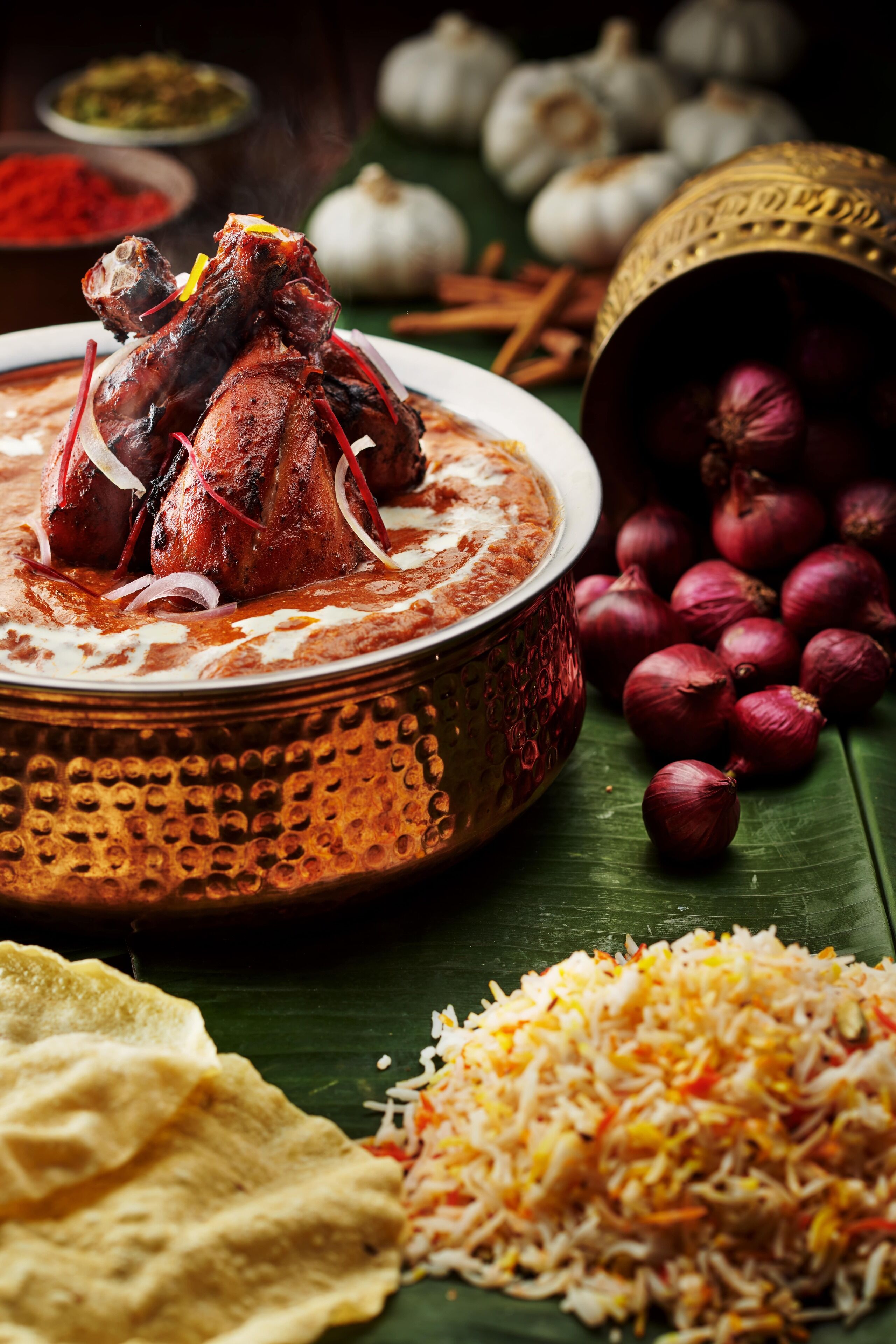 A traditional dish with a bowl, a plate of rice, and a banana leaf.