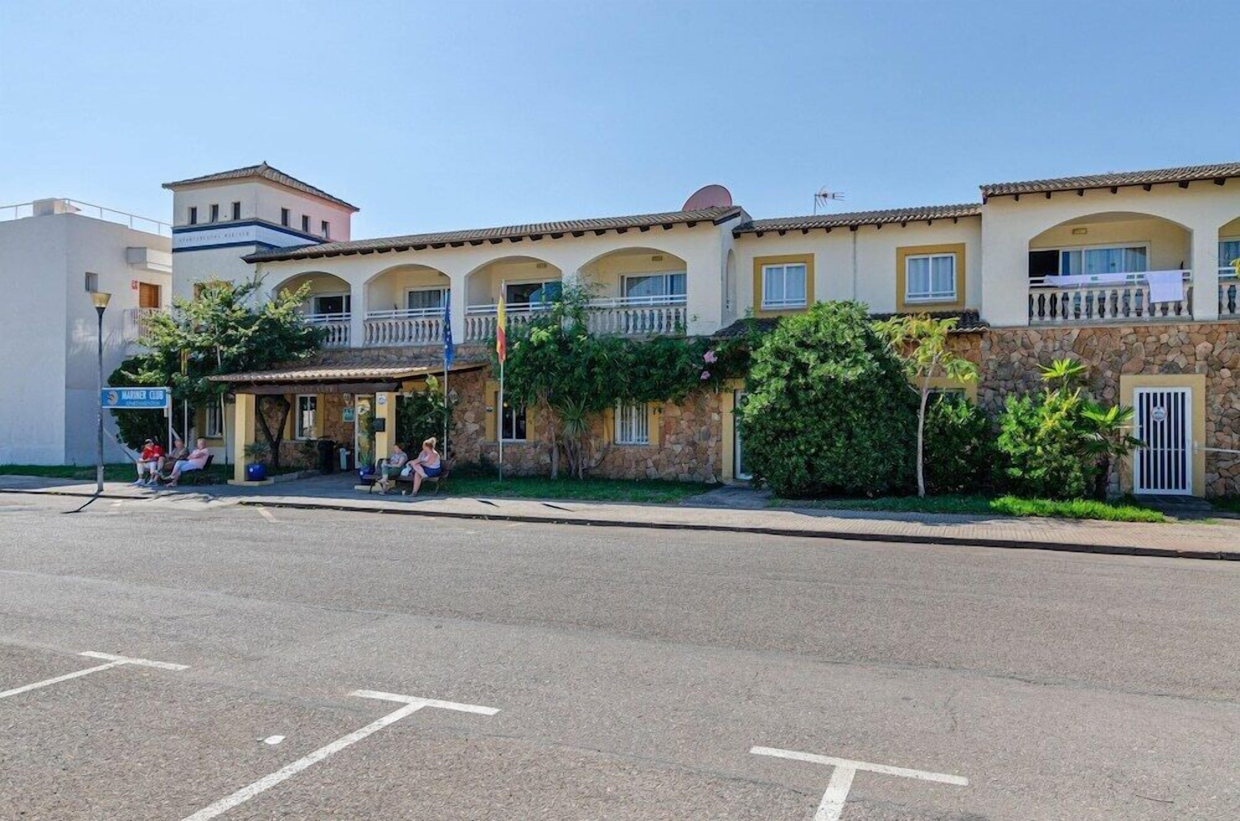 Hotel amb un pati central, diversos balcons i façana de pedra.