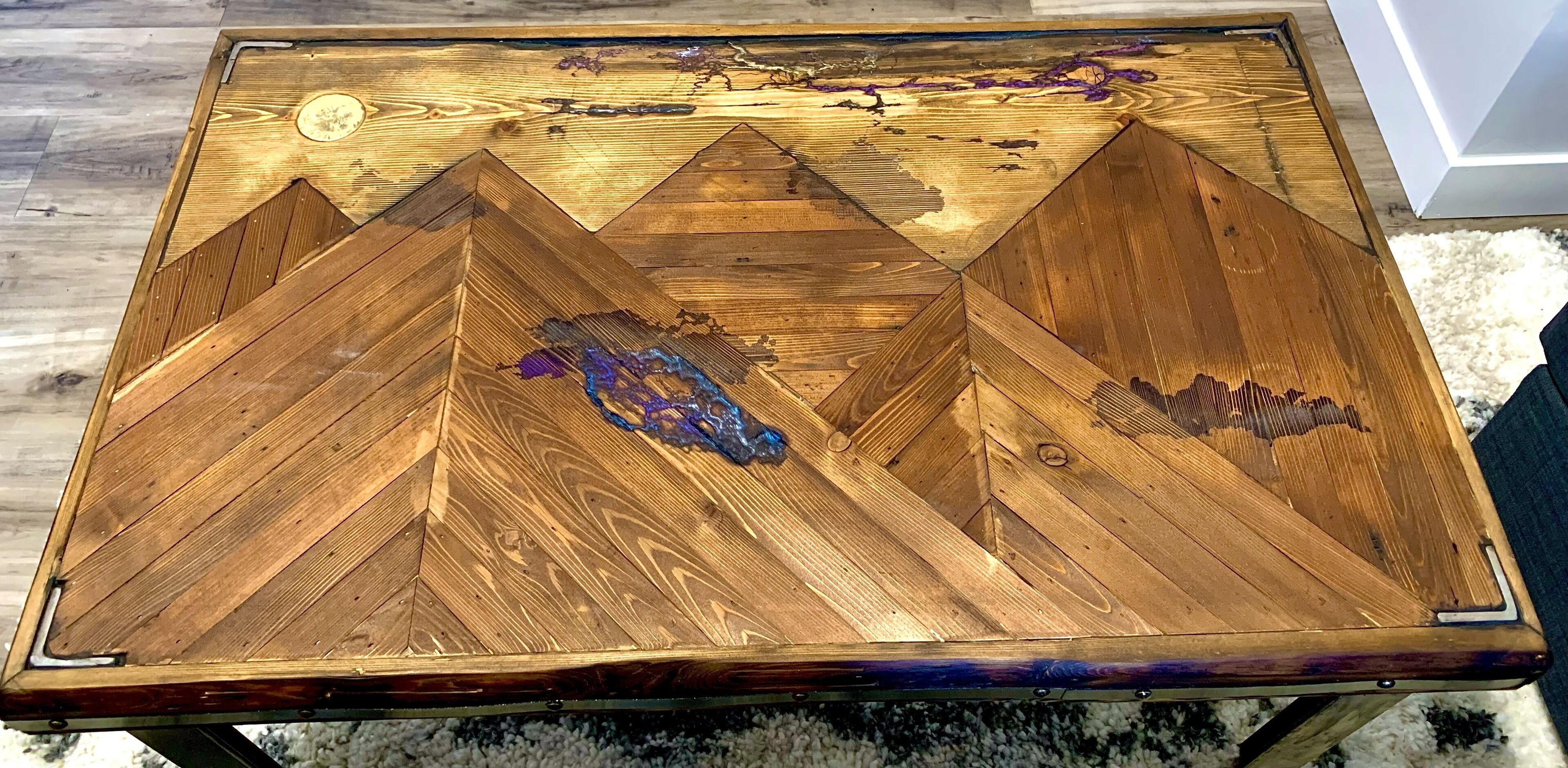 Una mesa de madera con un diseño geométrico y un pequeño adorno encima.