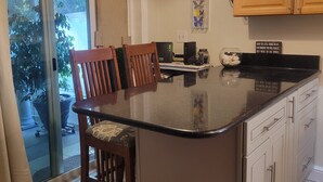 Una cocina con una isla central, sillas de madera, una mesa de comedor y armarios.