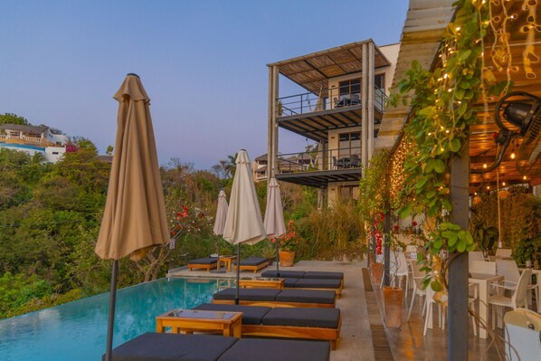 Una piscina al aire libre, sillones reclinables de piscina