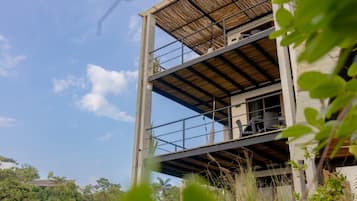 Experience the serene atmosphere of this modern building surrounded by lush greenery, with balconies offering a tranquil outdoor space.