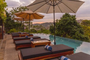Una piscina al aire libre, sillones reclinables de piscina