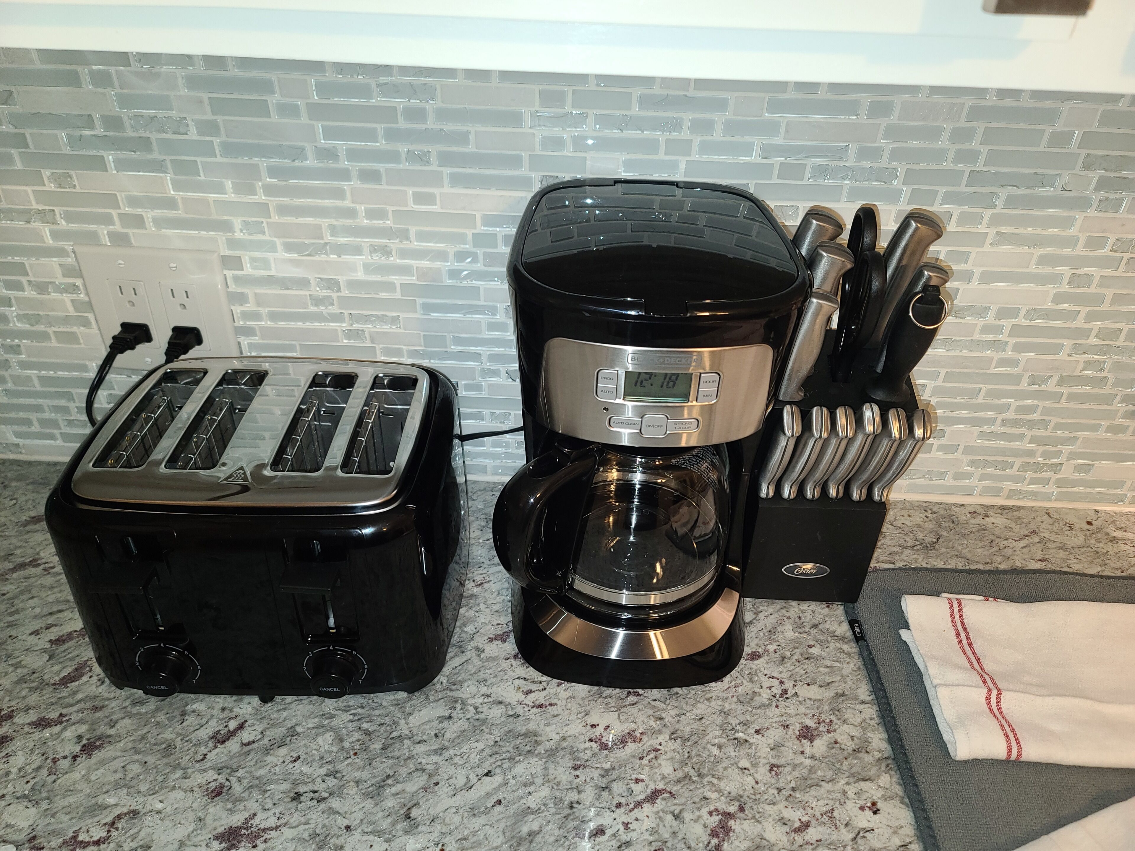 Een keuken met een broodrooster, een koffiezetapparaat en een messenblok.