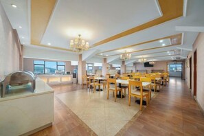 A spacious dining area with high ceilings and modern chandeliers.
