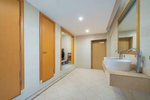 A bathroom with a large mirror, two sinks, and wooden doors.