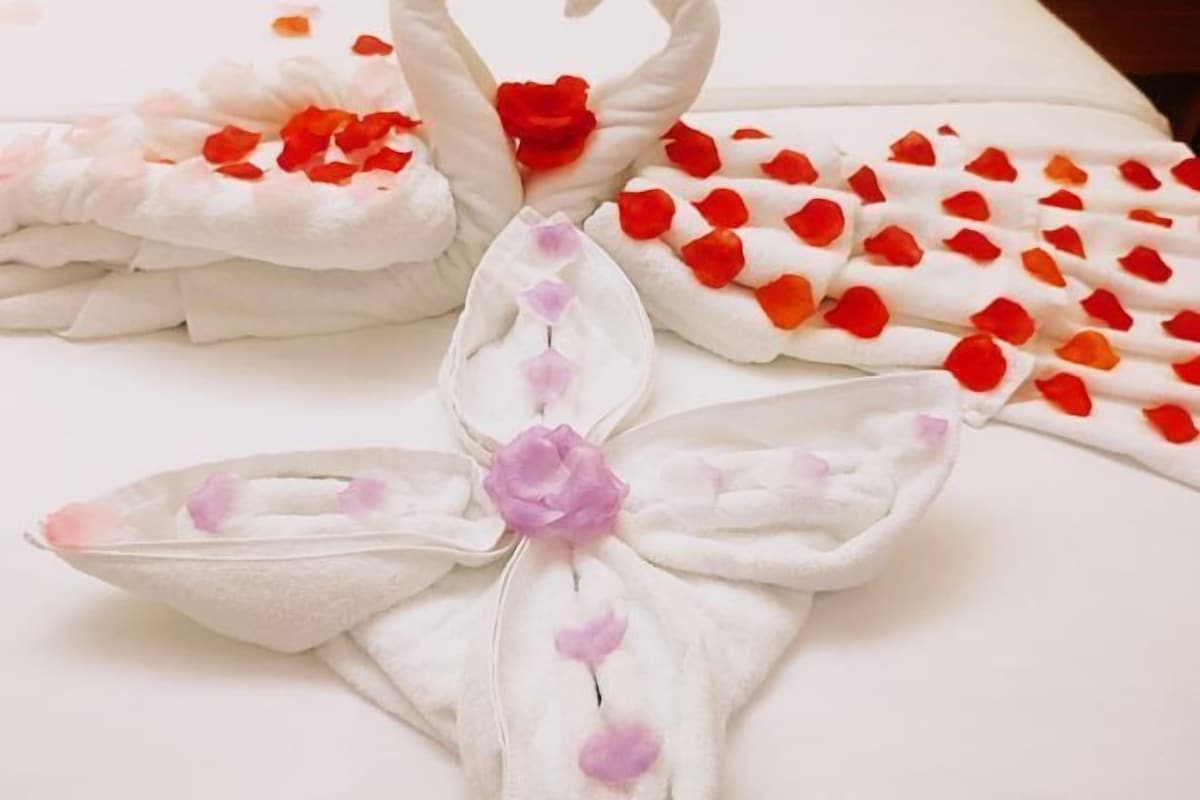 Una toalla con diseño de cisne y pétalos de rosa.