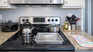 A kitchen with a stainless steel stove, a crockpot, a kettle, a pot, and a tray. - Waterfront Home, Stunning Canal Views, Deck (Navarre)