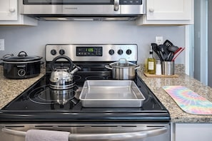 A kitchen with a stainless steel stove, a crockpot, a kettle, a pot, and a tray. - Waterfront Home, Stunning Canal Views, Deck (Navarre)