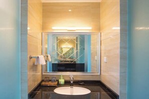 A bathroom with a large mirror, a round sink, and a towel rack. - Xile'er Hotel (Emeishan City)