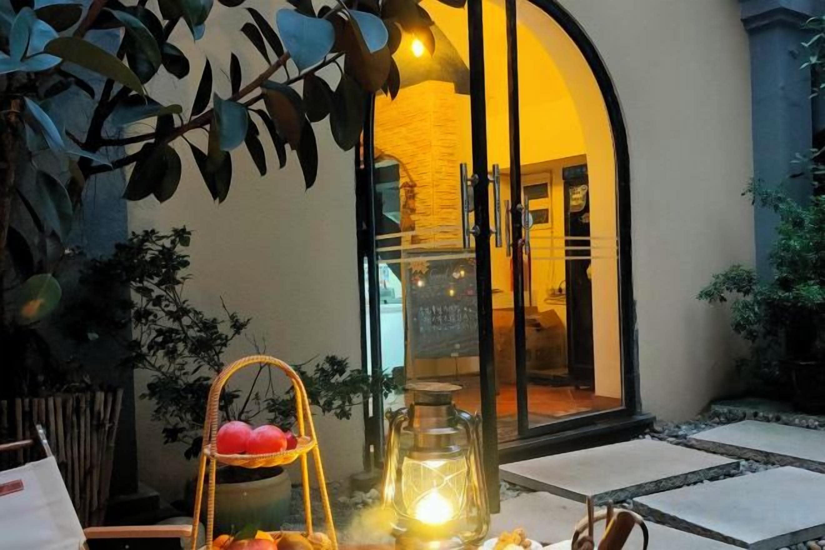 An outdoor seating area with a table, chairs, a lantern, and a decorative basket.