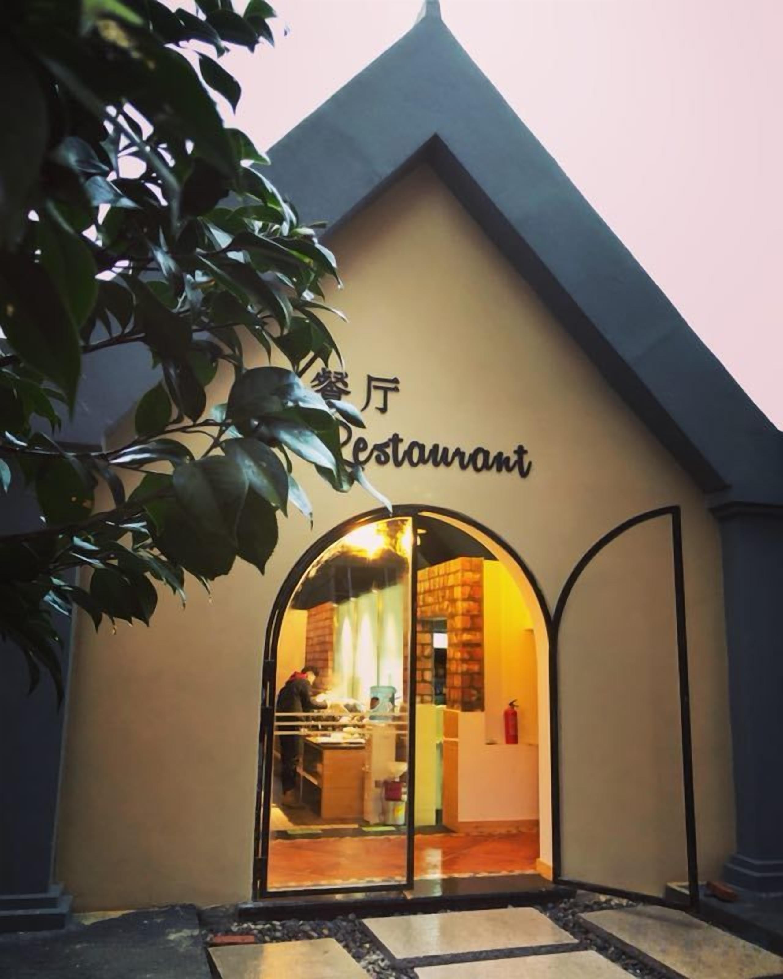 A restaurant with an arched entrance and a sign above it.