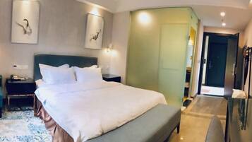 Ein Hotelzimmer mit einem großen Bett, Nachttischen, einer Bank und Kunstwerken an den Wänden.