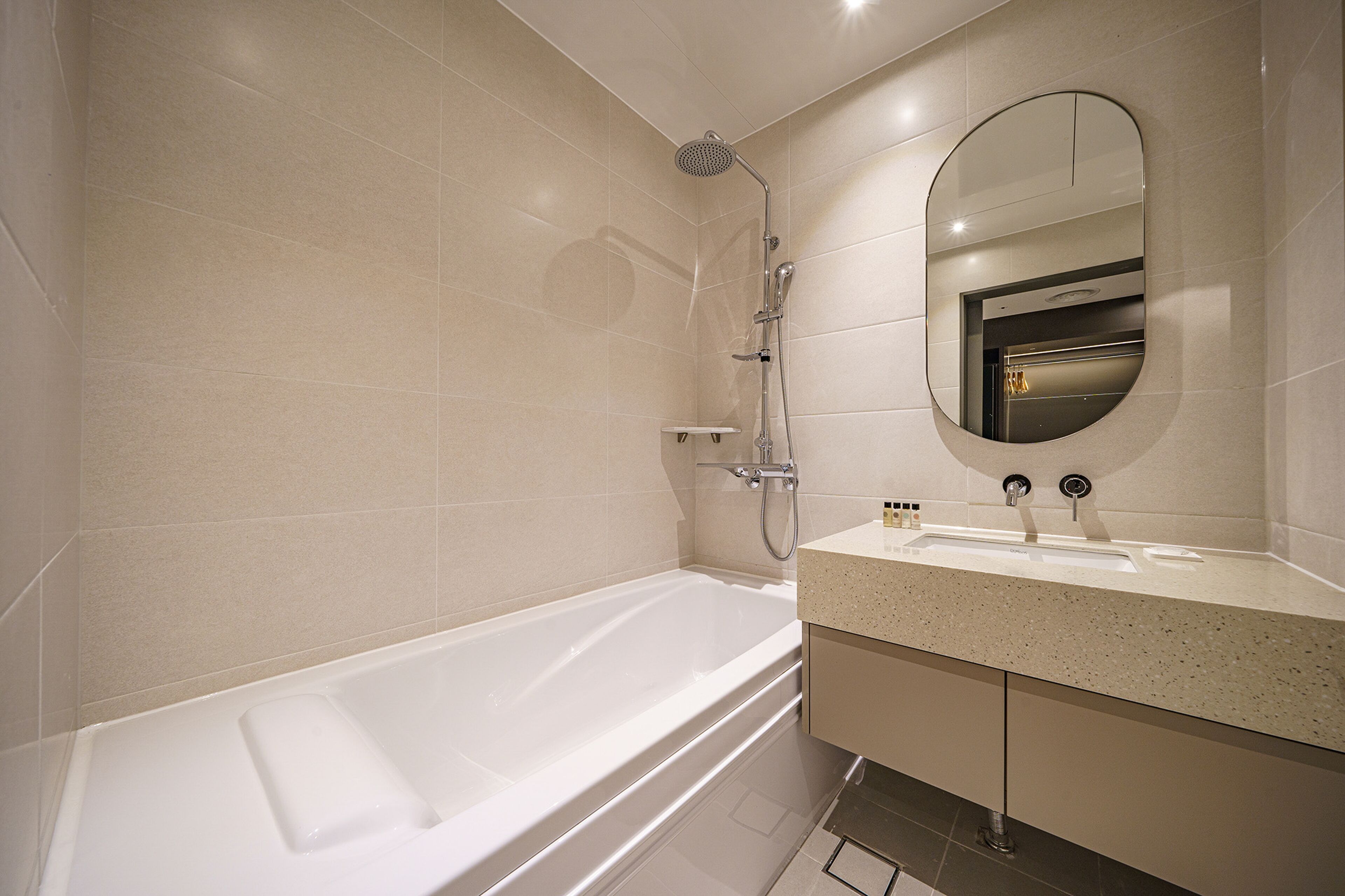 Un baño moderno con bañera, ducha y tocador con espejo.