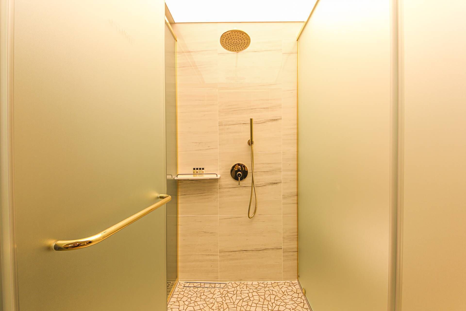 A small, enclosed shower area with a tiled floor and a single showerhead.