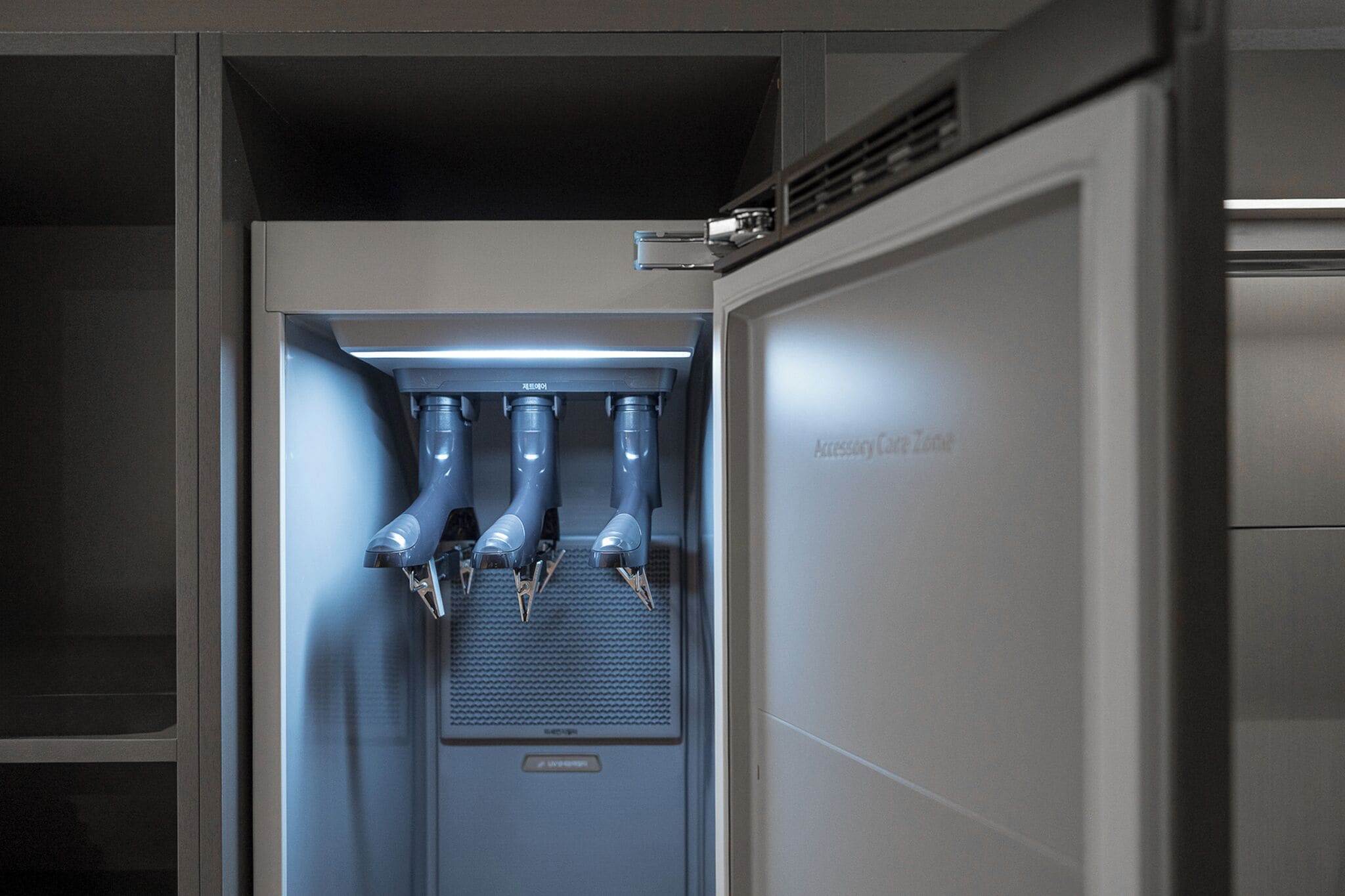 A water dispenser with multiple spouts, located in a modern, enclosed space with metallic and glass elements.