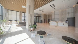A spacious lobby with a reception desk, seating areas, and a large open space with a high ceiling and natural light. - ACT Hotel (Daegu)