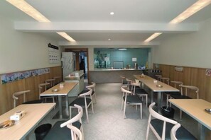Un restaurante con varias mesas y sillas, una barra y un suelo de baldosas.