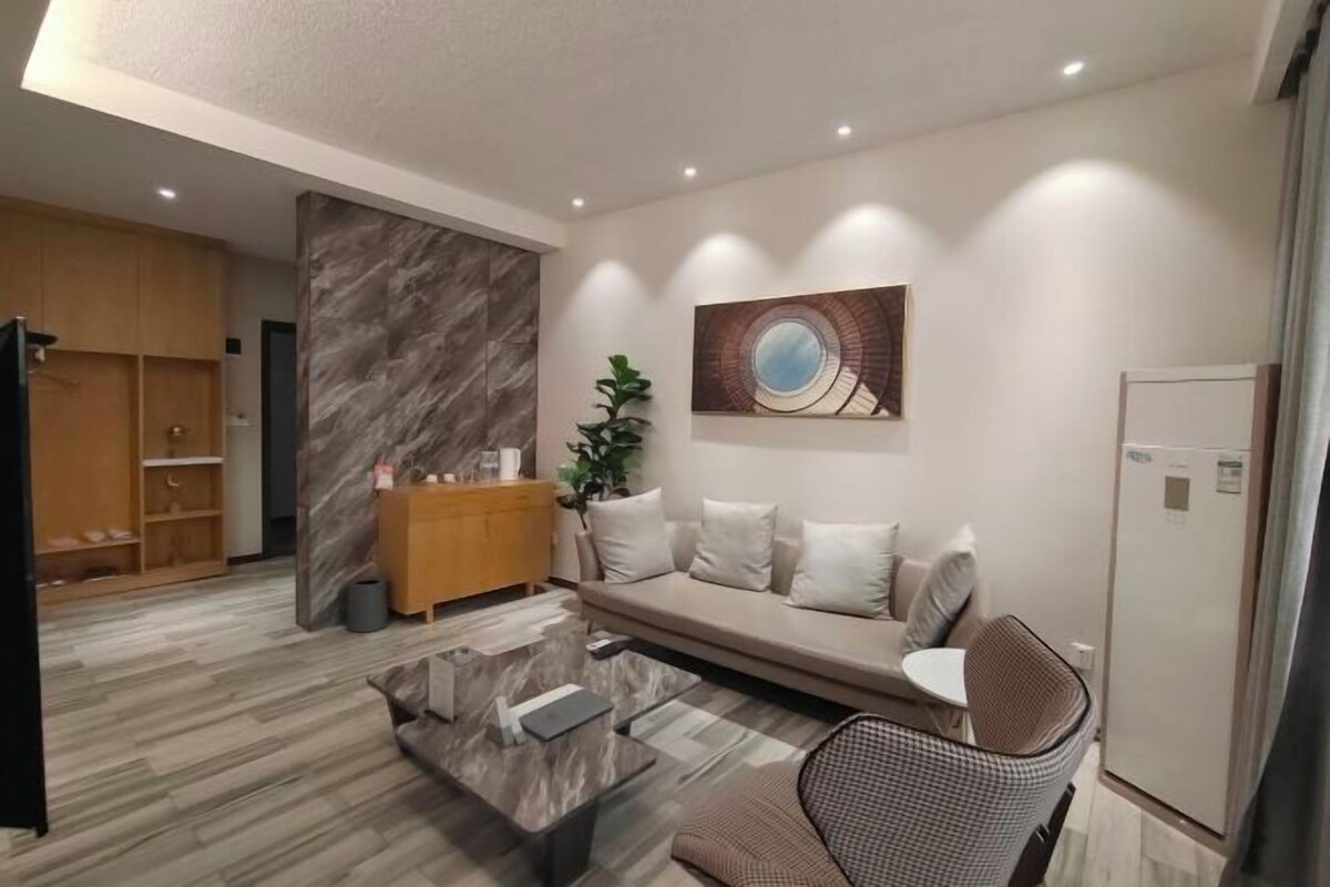 Ein modernes Wohnzimmer mit einer Couch, einem Couchtisch, einem Wandbild und einer Holzkommode.