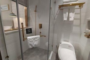 A modern bathroom with a glass shower enclosure, a toilet, and a towel rack.