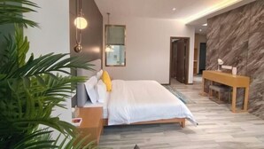 Un dormitorio moderno con cama, mesita de noche y escritorio con silla.