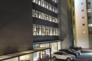 Un edificio de varios pisos con estacionamiento.