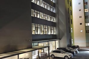 Un edificio de varios pisos con estacionamiento.