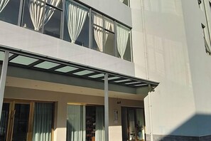 A modern building with a flat facade, large windows with curtains, and a covered outdoor area. - Yuxi Jiada Hotel (Yuxi)