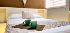 Relax in a cozy retreat with a neatly made bed and a convenient workspace.