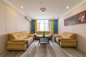 Una habitación con dos sofás de cuero, una mesa de centro de madera y un ventanal con cortinas amarillas y azules.
