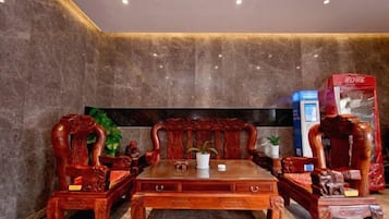 A room with a wooden table and chairs, a flat-screen TV, and a red box on the right.