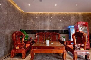 A room with a wooden table and chairs, a flat-screen TV, and a red box on the right.