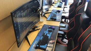A gaming setup with a curved monitor, two keyboards, and a gaming chair.