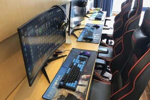 A gaming setup with a curved monitor, two keyboards, and a gaming chair. - Fujia Business Hotel (Fuyang)