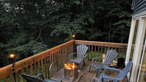 Une terrasse avec un foyer, des chaises et une table.