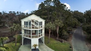 A two-story house with a balcony and a staircase leading to the upper floor. - Private Murrells Inlet Waterfront 4 Bedroom 4 Bath Home on Marsh with Fire Pit (Murrells Inlet)