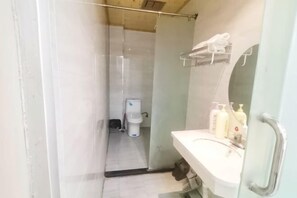 Un baño con ducha, inodoro y lavamanos.