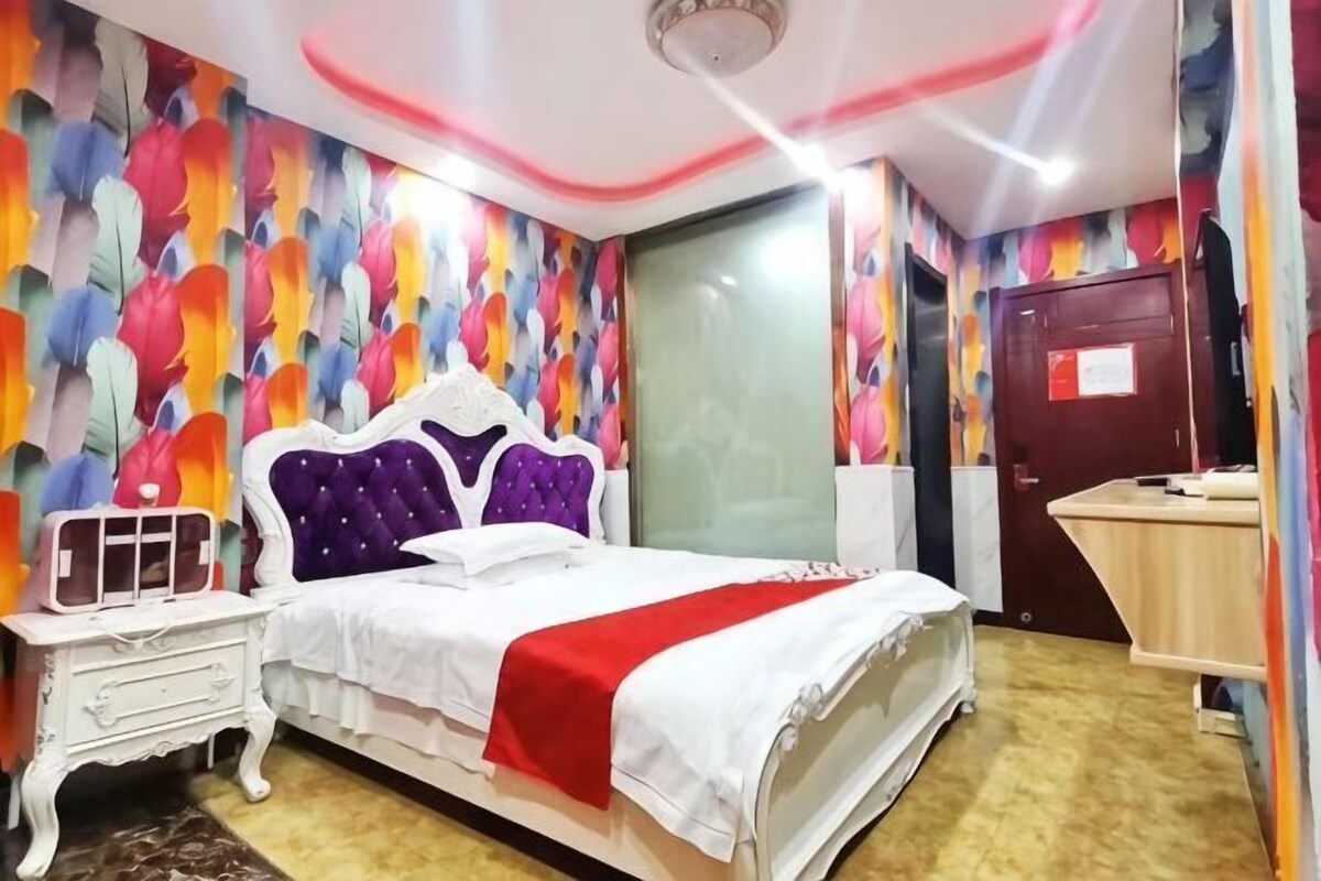 Un dormitorio con cama, mesita de noche y escritorio.