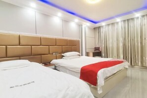 Habitación de hotel con dos camas, un cabecero moderno y un ventanal con cortinas.