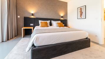 Une chambre d’hôtel moderne avec un grand lit, deux tables de chevet et une œuvre d’art accrochée au mur.