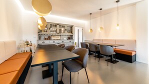 A modern kitchen with a dining area, featuring a large table, chairs, and pendant lighting. - Granja da Cabrita (Coimbra)
